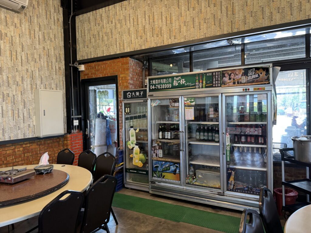 小霖甕缸鶏の店内ドリンク冷蔵庫と円卓席