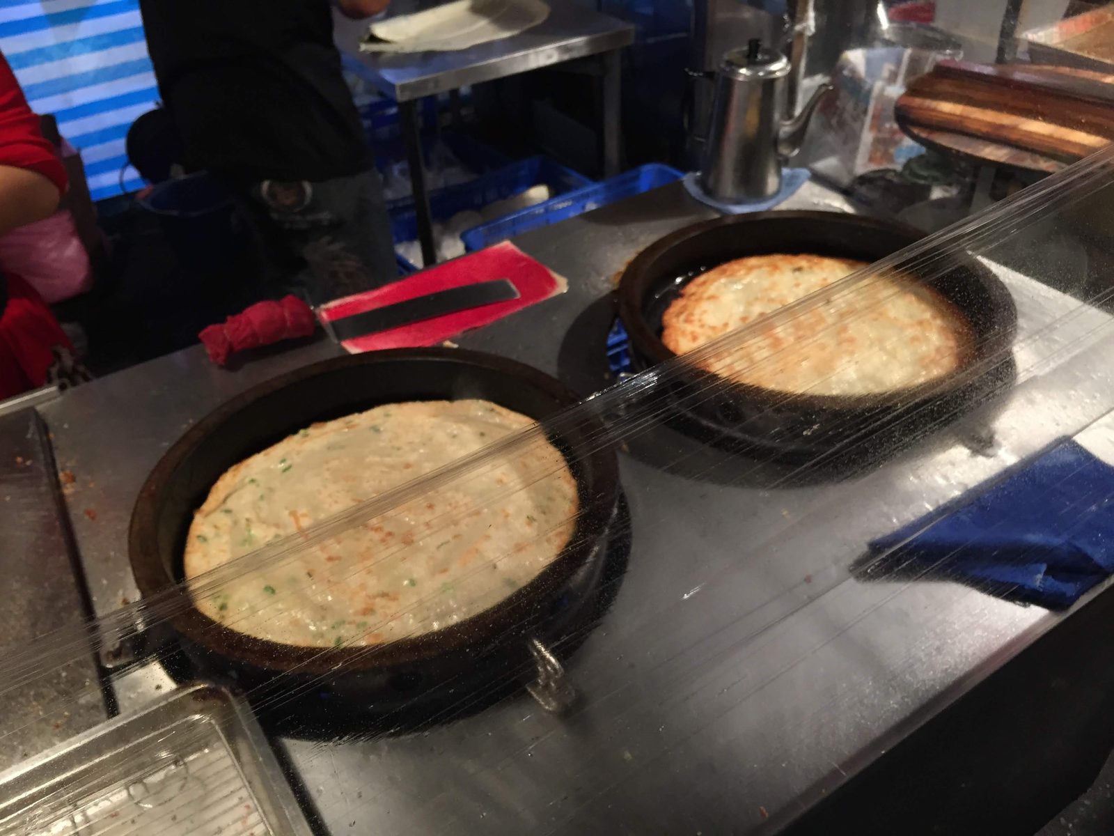 鉄鍋で焼かれる蔥抓餅と月亮蝦餅