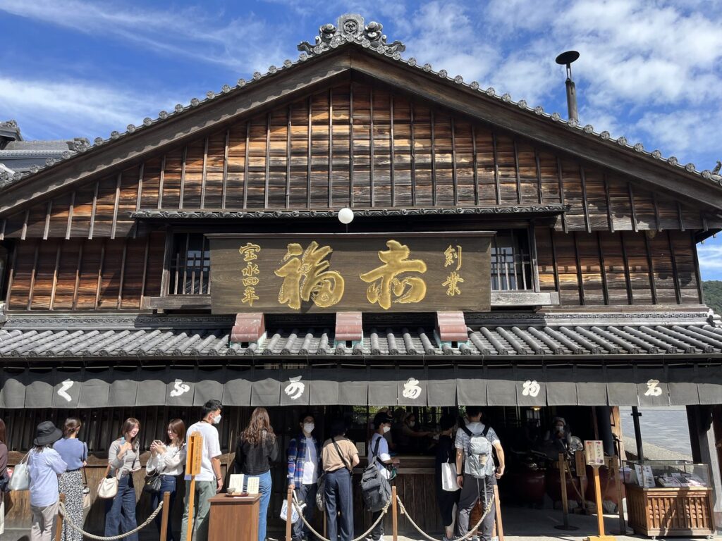 赤福本店の建物と店先に並ぶ参拝客