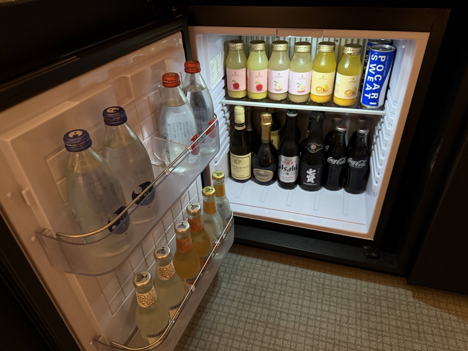 ジュースやシャンパン、ビール、トニックウォーターが並ぶ客室の冷蔵庫