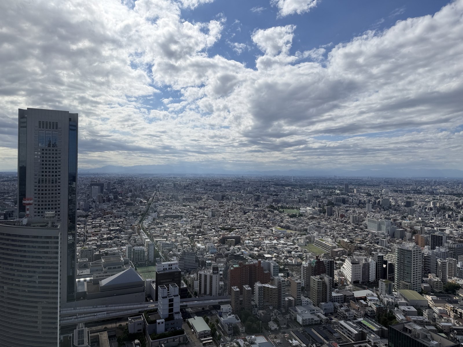 客室の窓から望む西新宿の超高層ビルと関東平野の眺望
