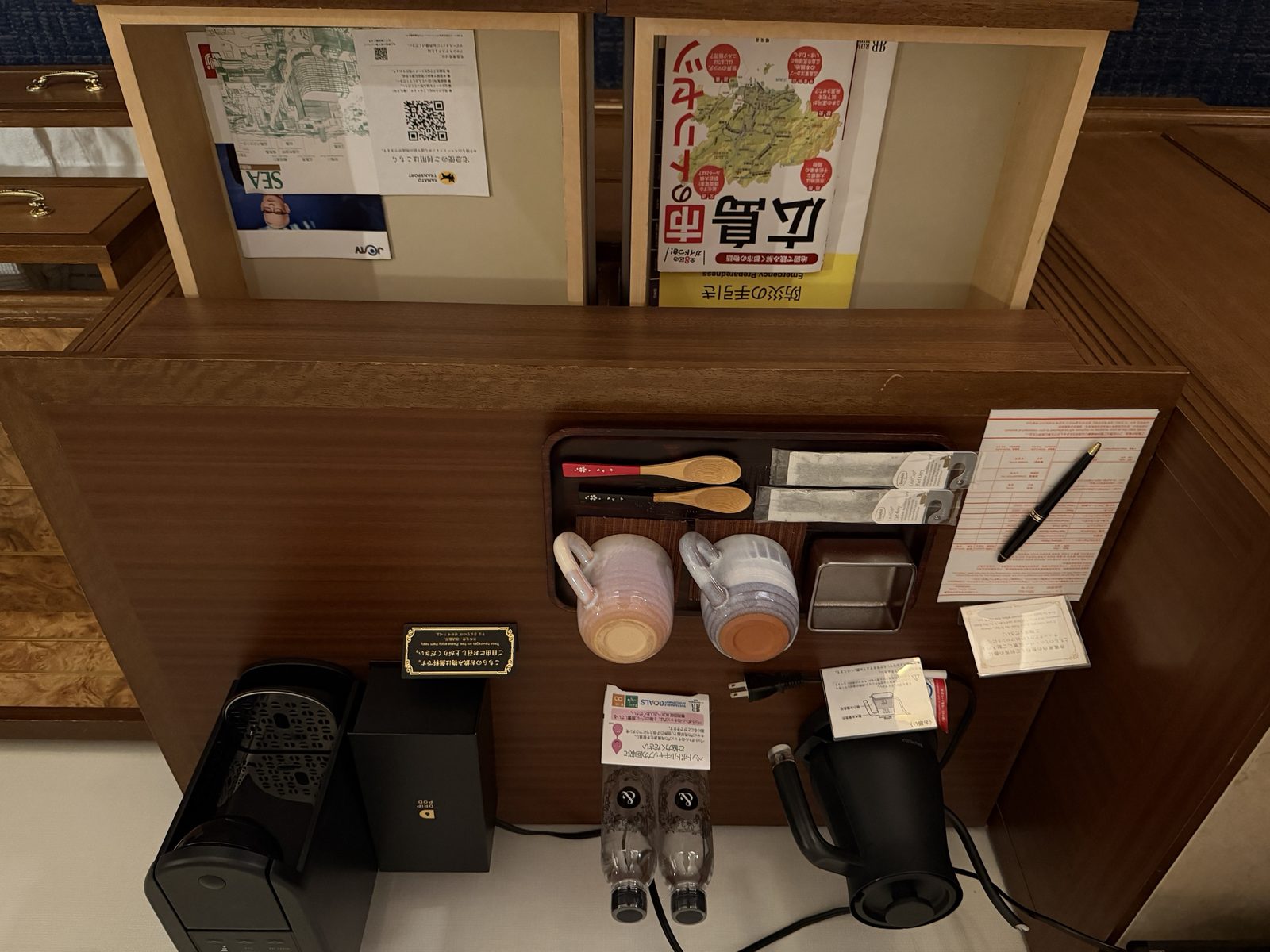 コーヒーマシン、電気ケトル、マグカップとティーバッグが並ぶチェスト上