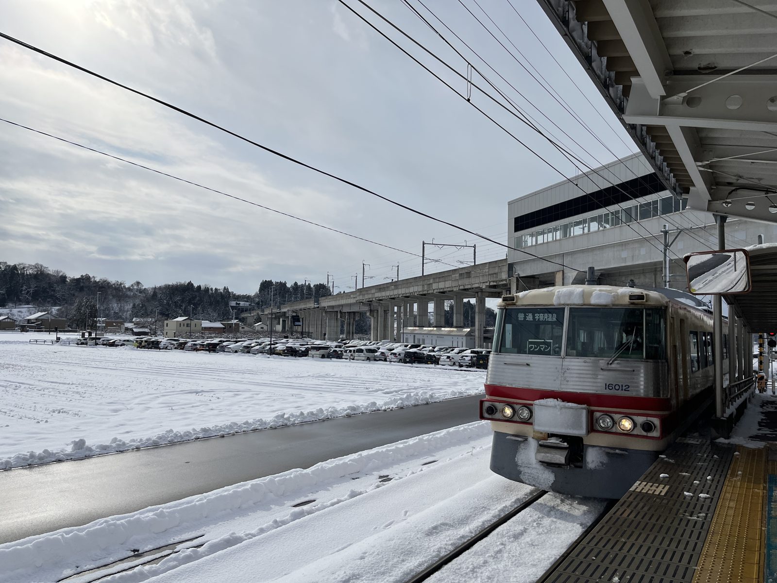 雪の宇奈月温泉駅に到着した富山地方鉄道の普通列車
