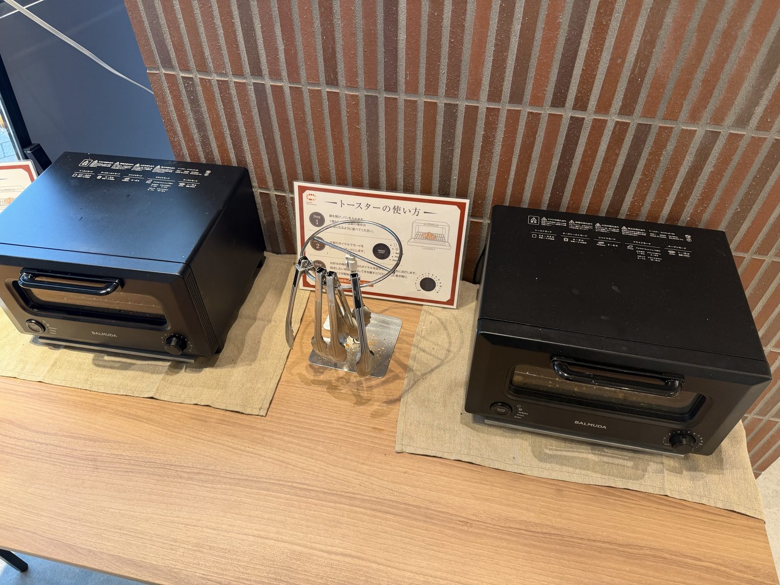店内窓際に置かれたバルミューダのトースター2台と使い方の案内