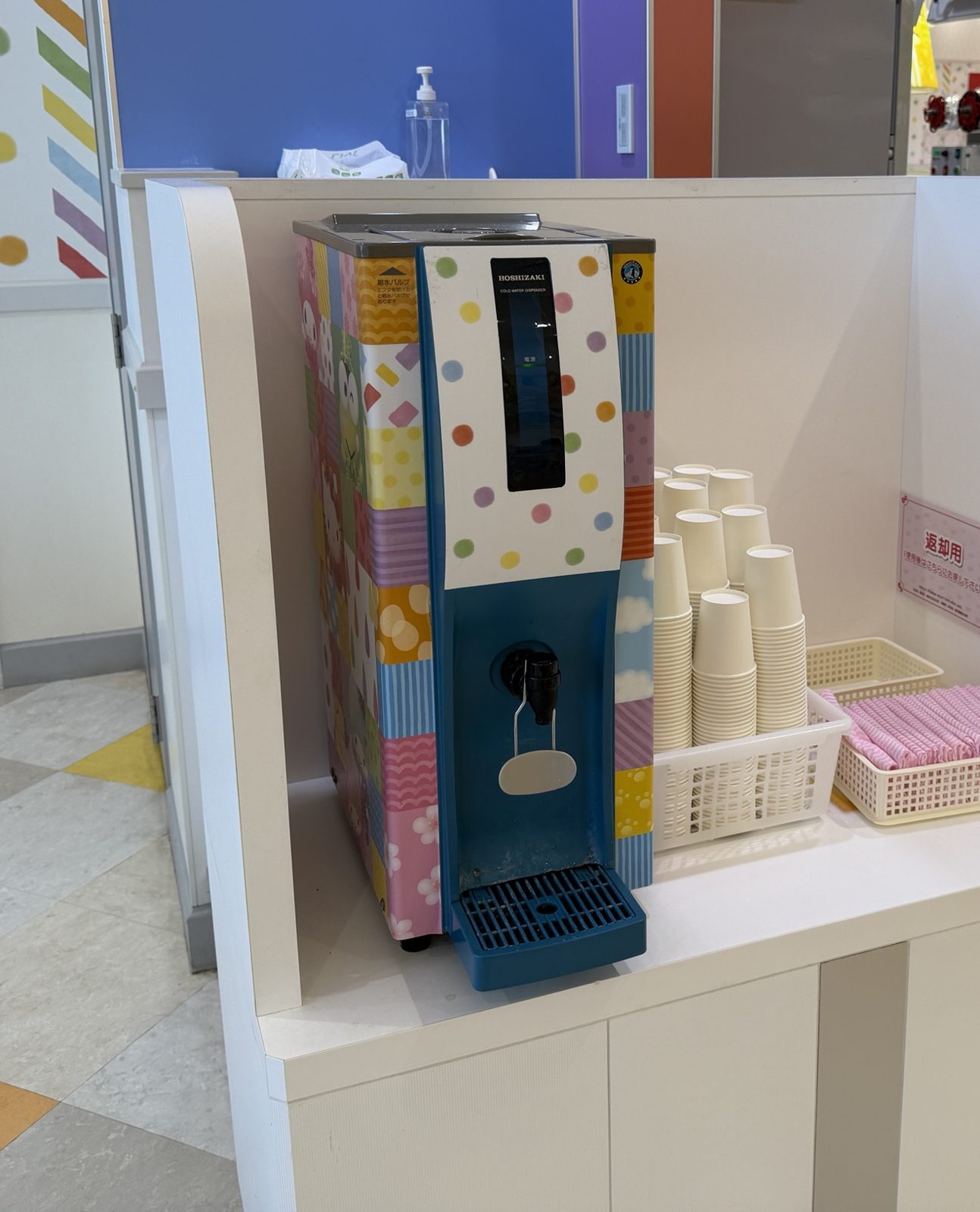 セルフサービスの給水機と紙コップ
